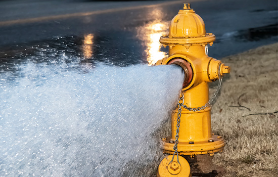 water being expelled from yellow fire hydrant