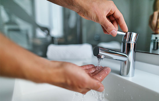 person checking water coming from tap