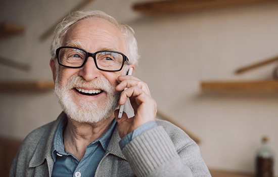 a smiling senior man on mobile phone